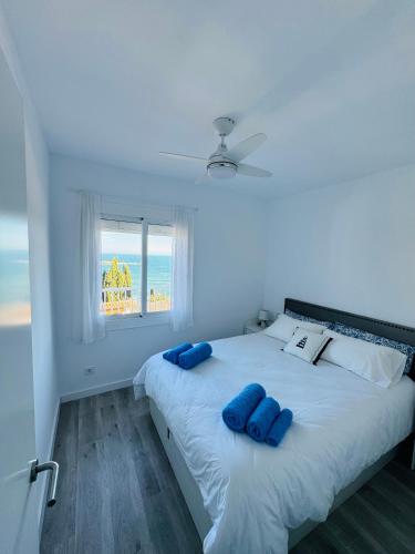 a bedroom with a bed with two blue pillows on it at Apartamento Canyelles playa in Roses
