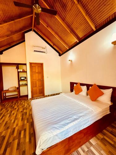 a bedroom with a large white bed with wooden floors at Sabba Beach Suite , Fodhdhoo - Maldives in Velidhoo