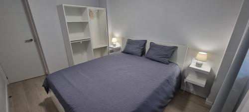 a bedroom with a blue bed with two pillows at Salinetas apartamento junto al mar in Telde