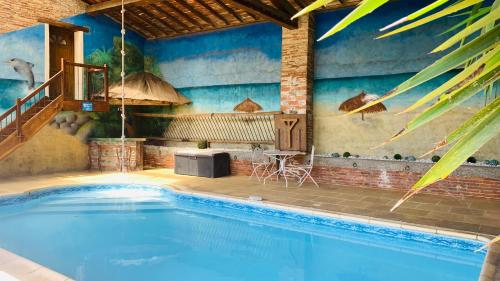 a large swimming pool with a table and a table at Chambres d'Hôtes Au Clos Saint Georges in Saint-Jory
