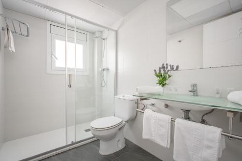 a white bathroom with a toilet and a sink at Hotel Tolosa in Salou