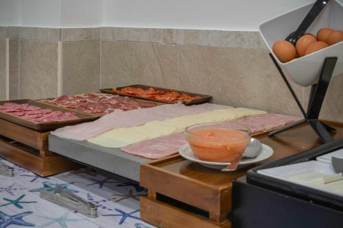a table with different types of pizzas and eggs at Hotel Tolosa in Salou