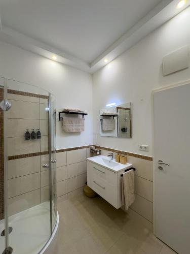a white bathroom with a shower and a sink at Schlachte-Studio No5 in Bremen