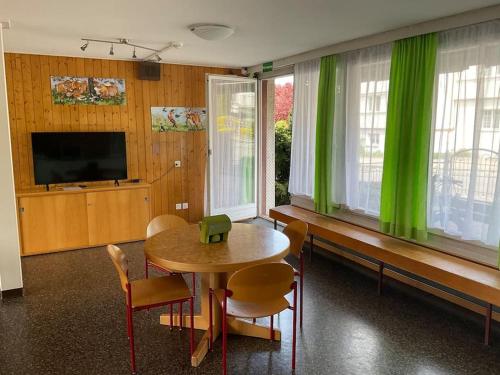 a dining room with a table and green curtains at 12 - Gästehaus Erika - Hundwil - Appenzellerland in Hundwil