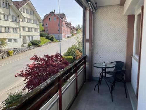 a balcony with a table and a view of a street at 12 - Gästehaus Erika - Hundwil - Appenzellerland in Hundwil