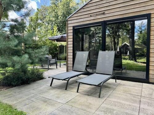 two chairs and a table on a patio at Holiday Home Maridu Wellness in Arnhem