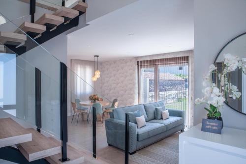 a living room with a blue couch and a table at Casa A LAXE in Vilagarcia de Arousa