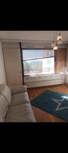 a living room with a couch and a large window at Private room in apartment near airport area vantaa in Vantaa