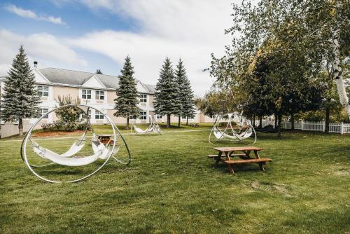 a park with two swings and a picnic table at Hôtel Le Bonne Entente in Quebec City