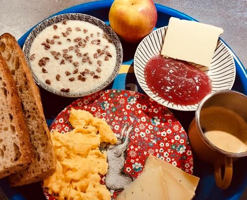 een blauw bord met eten, brood en appels bij Le nid des Petits à 15 min de Bordeaux in Sainte-Eulalie