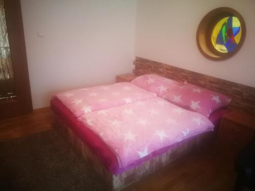 a pink bed in a room with a mirror at Villa Barrandov pokoj 3 in Prague