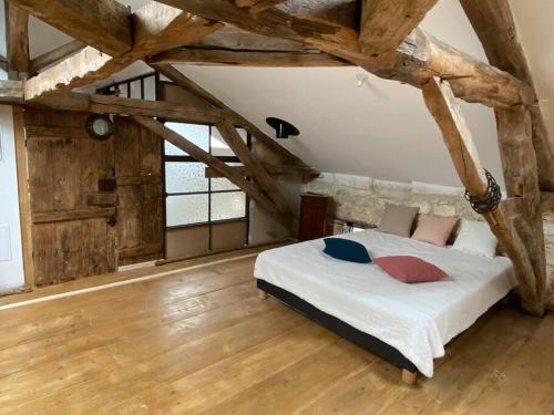 - une chambre avec un lit dans un dortoir doté de parquet dans l'établissement domainelachevalerie, à Chapdeuil