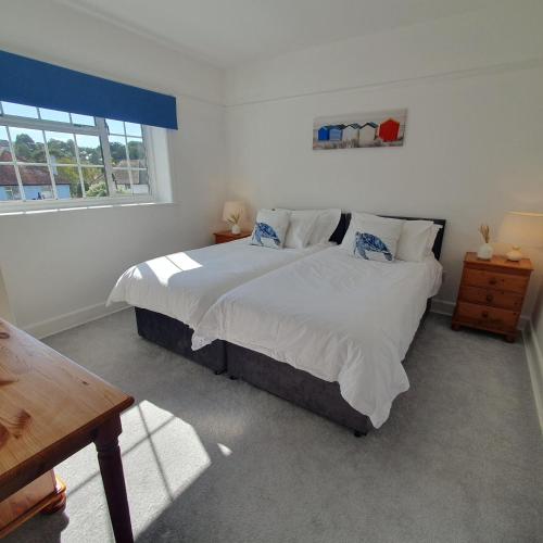 a bedroom with a large bed and a window at Panorama House - 400m from Sandbanks beach in Sandbanks