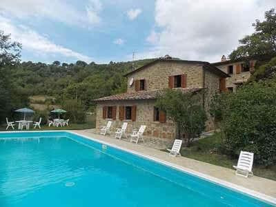 a house with a swimming pool in front of a house at Villa Il Corniolo in Morra