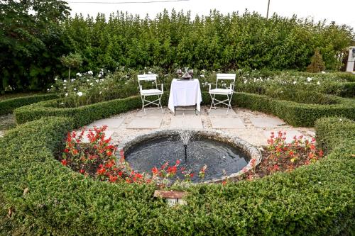 a table and chairs in a garden with a fountain at Glamping Home in Bukovik