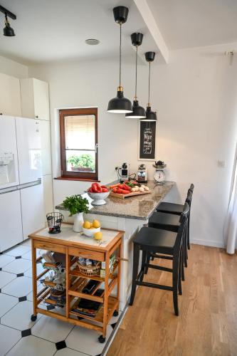 a kitchen with a counter with chairs and a table at Glamping Home in Bukovik