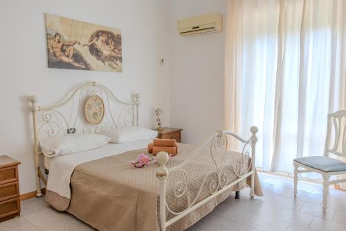 a bedroom with a white bed with flowers on it at Casa Vacanza Mary in Guardavalle