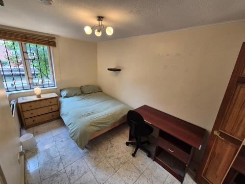 a bedroom with a bed and a desk and a desk at Spacious and Elegant Guest House with En-Suites available in Canary Wharf in London