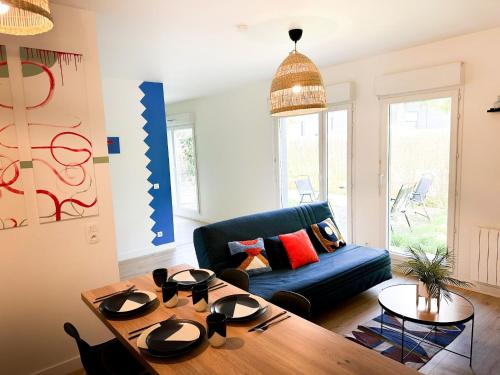 un salon avec un canapé bleu et une table dans l'établissement Appartement disneyland, à Montévrain