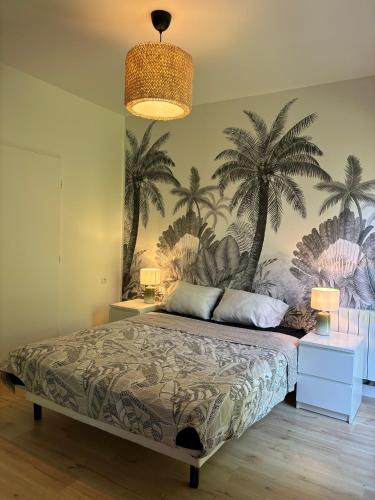 - une chambre avec un lit recouvert de palmiers dans l'établissement Appartement disneyland, à Montévrain