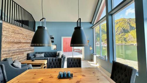 a dining room with a table and chairs and large windows at Ballstad Mountain Panorama in Ballstad