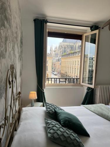 une chambre avec un lit avec une grande fenêtre dans l'établissement Royal Home, hypercentre Reims avec vue Cathédrale, à Reims