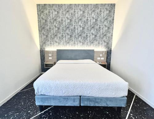 a small bedroom with a bed and a wall at Hotel Al Capo in Varigotti