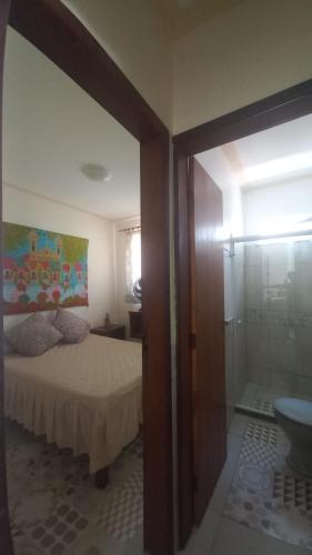 a bedroom with a bed and a glass shower at Souzas House in Vera Cruz de Itaparica