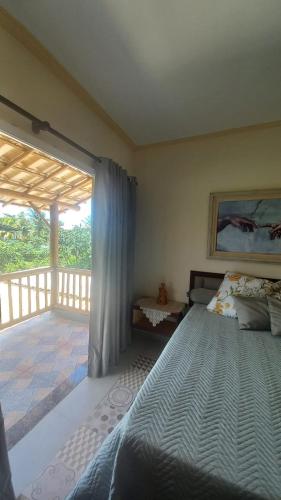 a bedroom with a bed and a balcony at Souzas House in Vera Cruz de Itaparica