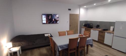 a room with a table and a bed and a kitchen at Sosnówka Pokoje Gościnne in Borne Sulinowo