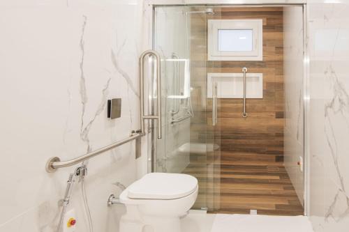 a white bathroom with a toilet and a shower at Hotel Kindermann Chapecó - Hotel Novo in Chapecó