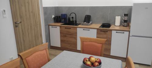 a kitchen with a table with a bowl of fruit on it at Sosnówka Pokoje Gościnne in Borne Sulinowo