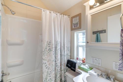 a bathroom with a shower curtain and a sink at Lakeland Cottage with Pool Access and Screened Porch! in Lakeland