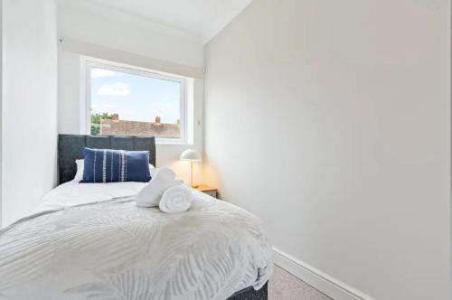a bedroom with a bed with two towels on it at Charming 4 Bedroom 3 Bathroom House - Sleeps up to 9 - Pool Table, Sky TV & Netflix, Fast WiFi, Driveway Parking & Self-Check-In By Yoko Property in Great Malvern