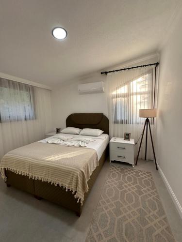 a bedroom with a large bed and a window at Beach Suites - İçmeler in Icmeler