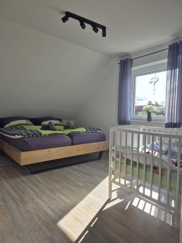 a bedroom with a bed and a window and a crib at Fewo RoBBe in Wangerland