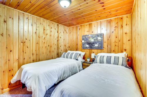 two beds in a room with wooden walls at Hike, Fish, Unwind and Relax Lodi Lake Escape! in Lodi