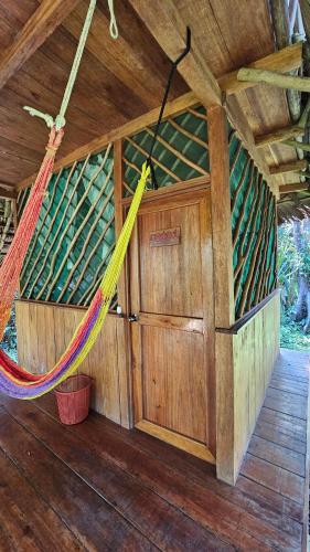 a hammock in the inside of a wooden cabin at El Hotelito Perdido in Rio Dulce
