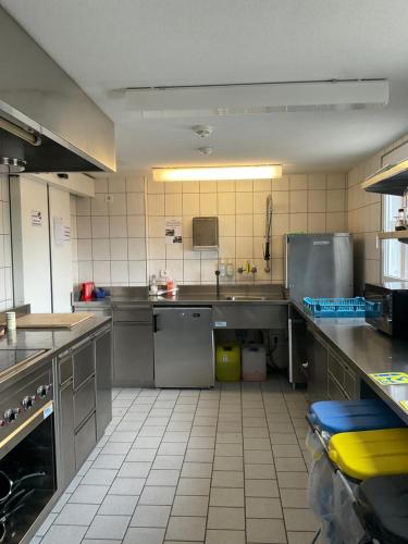 a large kitchen with stainless steel counters and appliances at 16 - Gästehaus Erika - Hundwil - Appenzellerland in Hundwil