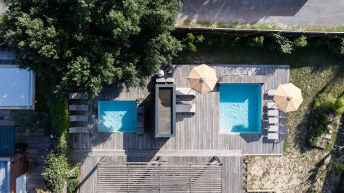 an overhead view of a swimming pool with umbrellas at Villa Contis Plage in Lit-et-Mixe