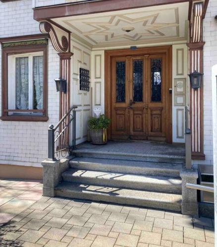 a house with a wooden door and stairs in front at 16 - Gästehaus Erika - Hundwil - Appenzellerland in Hundwil