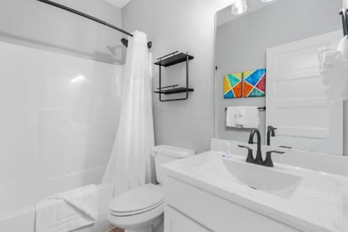 a white bathroom with a toilet and a sink at Table Rock Lake Views, Free Daily Attraction Tickets, Cmty Amenities w Pools in Kimberling City