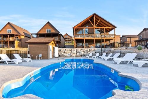 a pool with chairs and a house in the background at Table Rock Lake Views, Free Daily Attraction Tickets, Cmty Amenities w Pools in Kimberling City