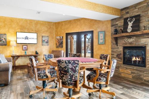 a dining room with a table and chairs and a fireplace at Grin Inn Bear It in Branson