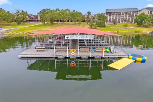 a dock with a table and an umbrella on a body of water at Grin Inn Bear It in Branson