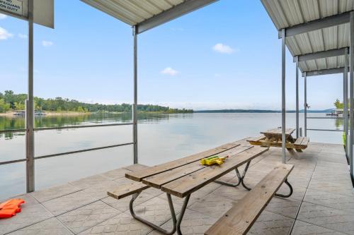a porch with a wooden bench and a view of the water at Grin Inn Bear It in Branson