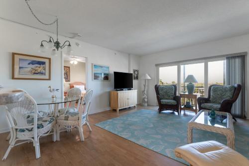 a living room with a table and chairs at Spacious 3BR Beachfront Condo with Balcony & Parking in Satellite Beach