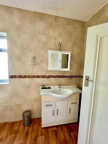 a bathroom with a sink and a mirror at Coastal Park Accommodation in Llanelli