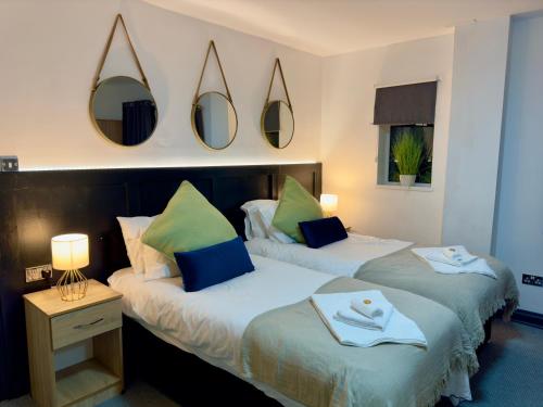 two beds in a room with mirrors on the wall at Coastal Park Accommodation in Llanelli