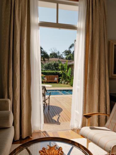 a living room with a door open to a patio at Hotel das Cataratas, A Belmond Hotel, Iguassu Falls in Foz do Iguaçu